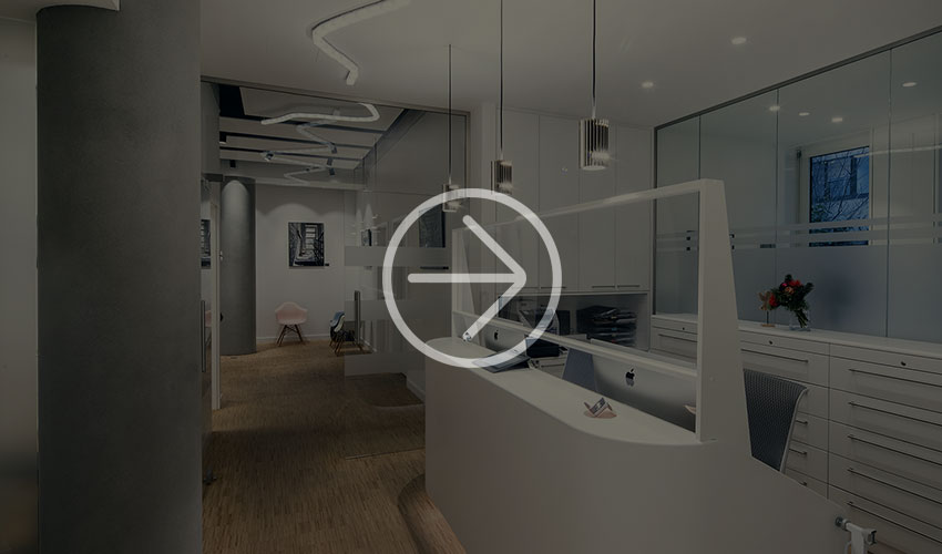 A modern office reception area with white decor, elegant furniture and atmospheric lighting that creates a welcoming atmosphere.