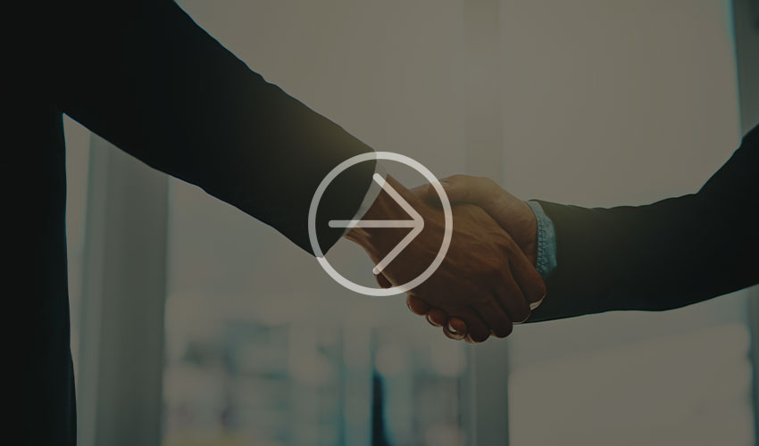 Two business people shake hands, symbolizing agreement, partnership and cooperation in a modern office environment.