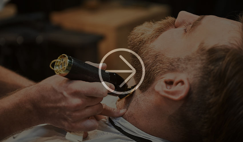 Close-up of a man getting his beard trimmed.